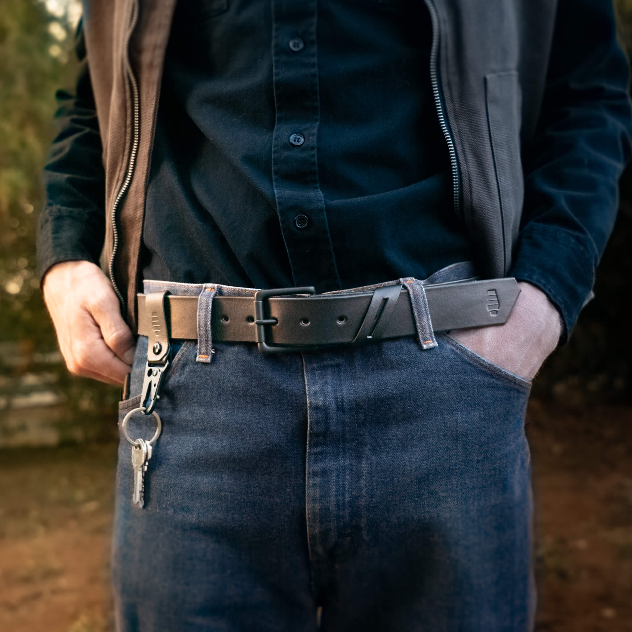 Person wearing a black leather belt with a matching keychain.