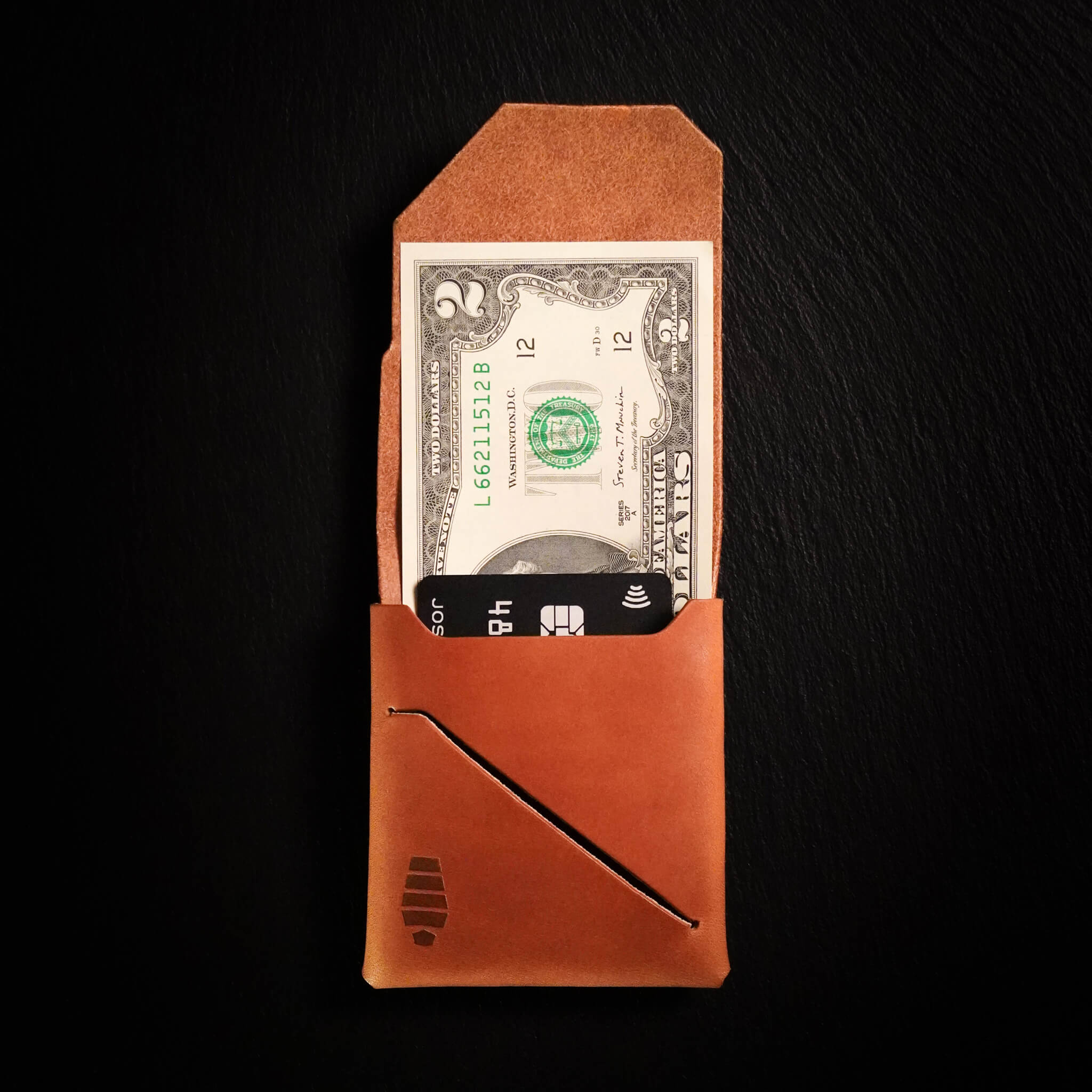 Voyager minimalist wallet in canyon brown unfolded and open showing cash visible in Tuck & Go billfold pocket and its slim profile with stitchless leather construction