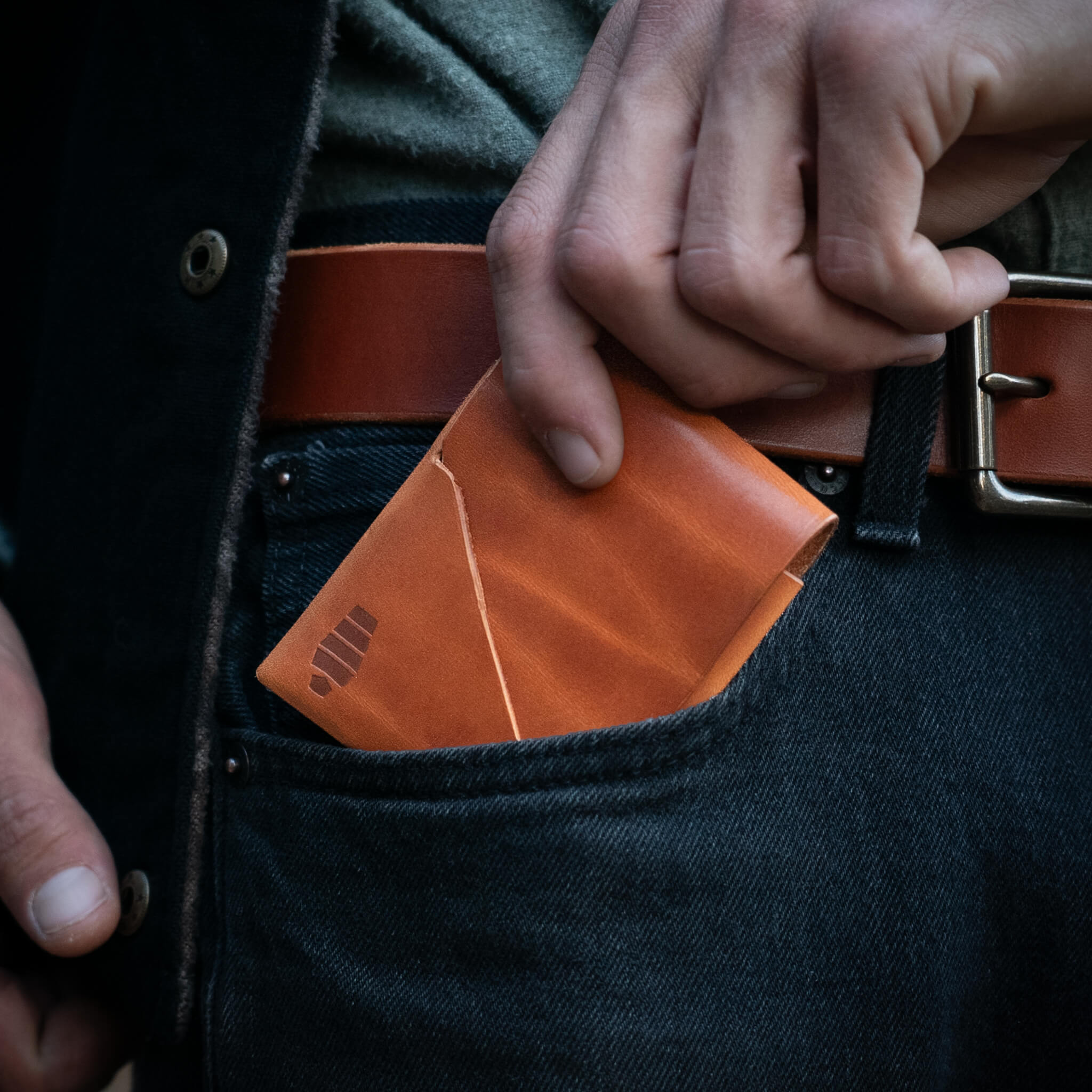 Voyager minimalist wallet sliding into front jeans pocket showing slim everyday carry profile and accessibility