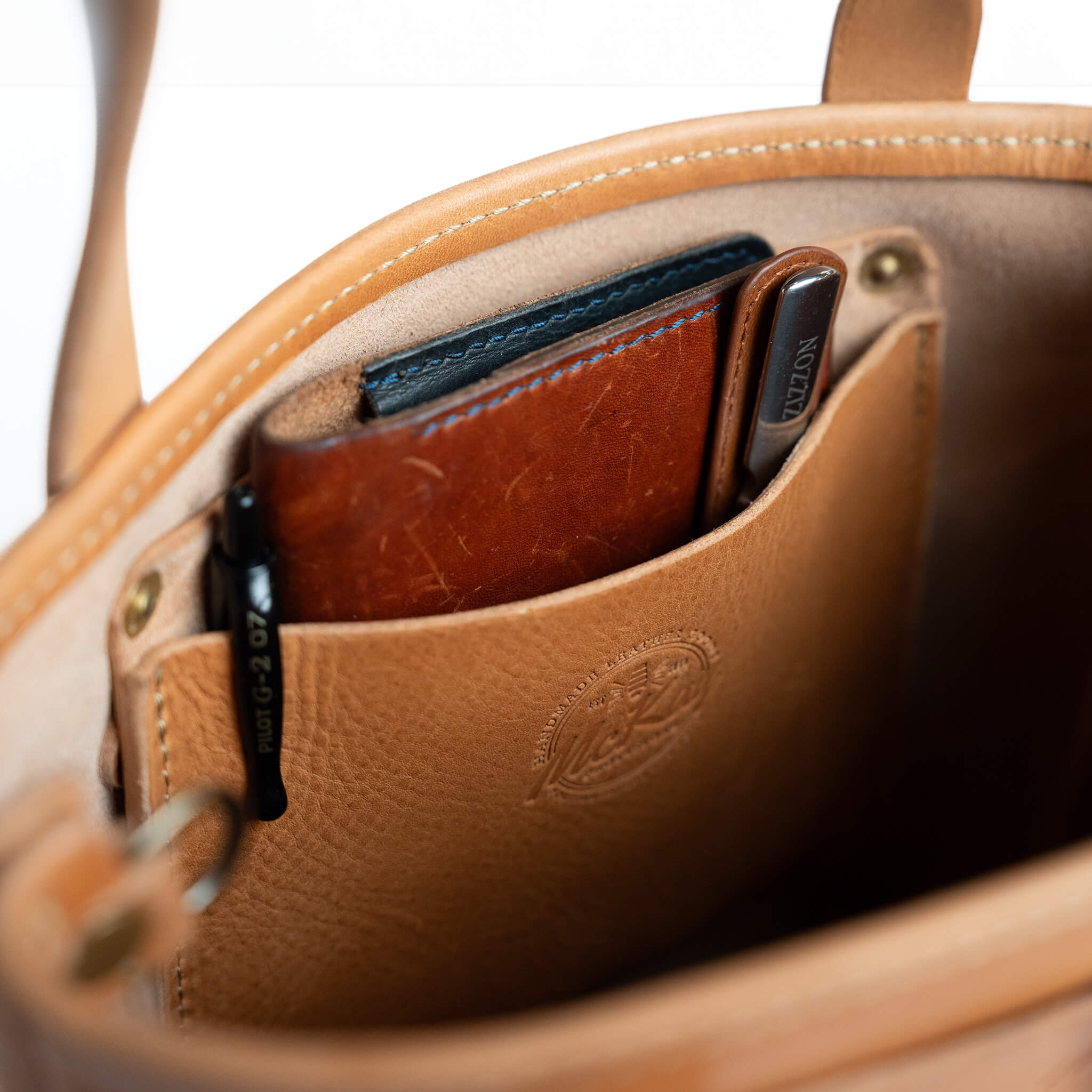 Leather mini tote bag interior pocket with items inside McKay full grain construction