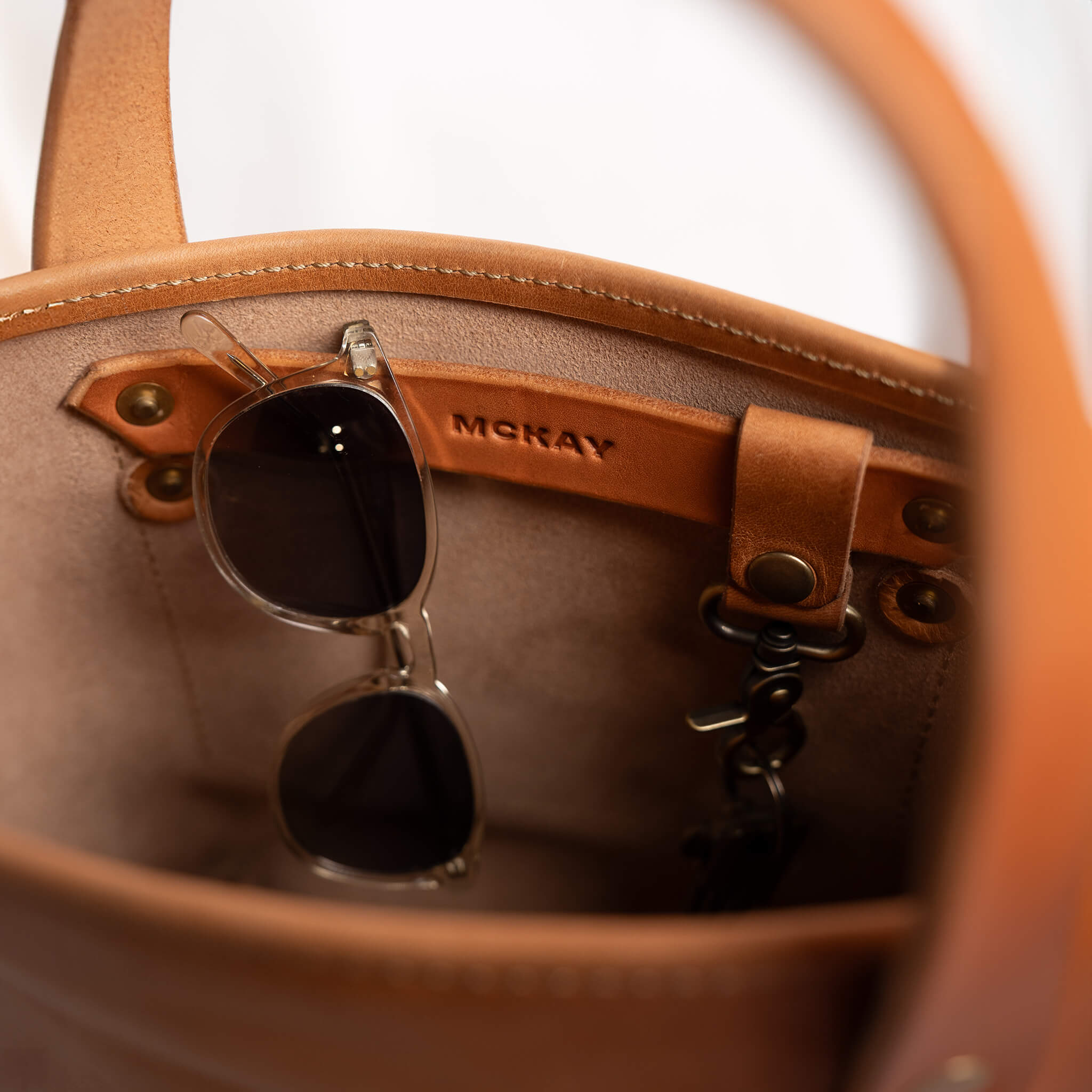 Mini tote bag inner sunglasses strap with key clip keychain pocket organization McKay full grain leather interior storage detail