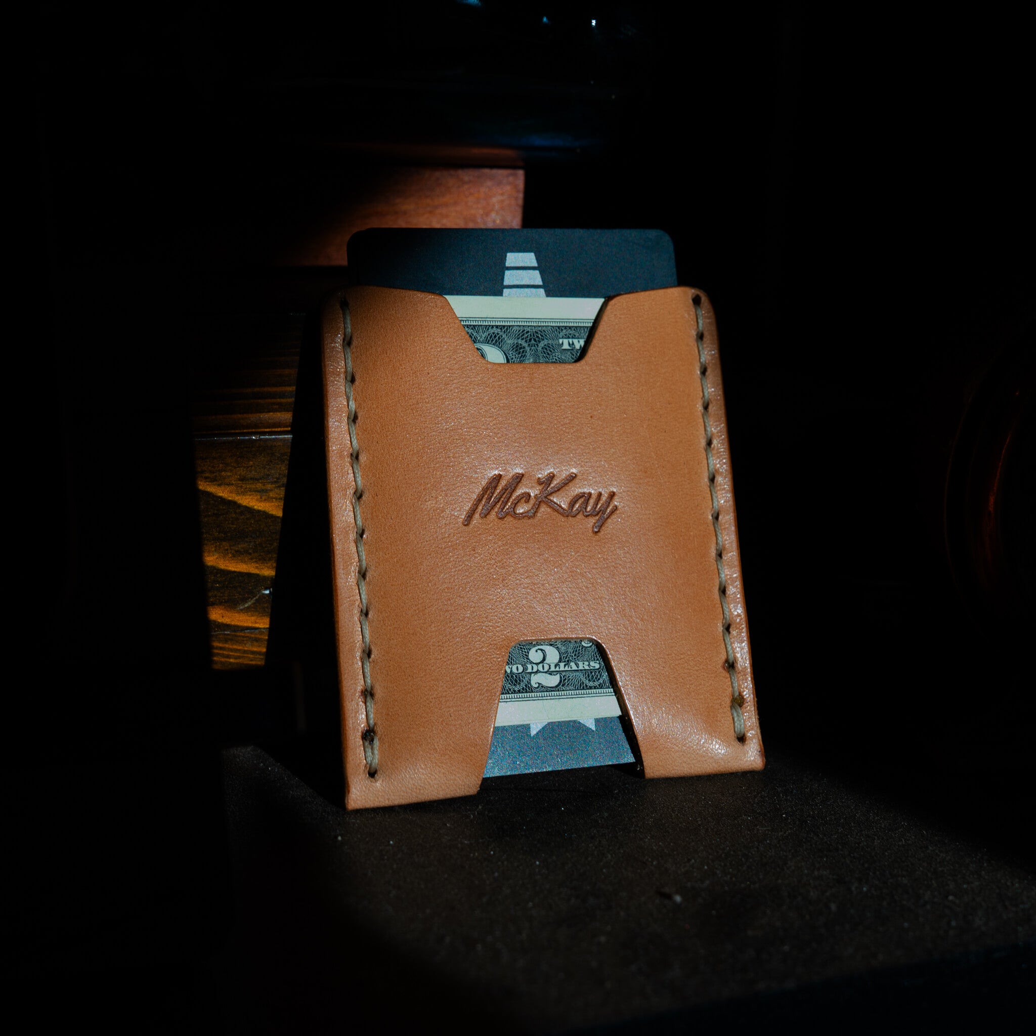 Ulysses leather card wallet with credit card and cash stored, full-grain leather patina visible.