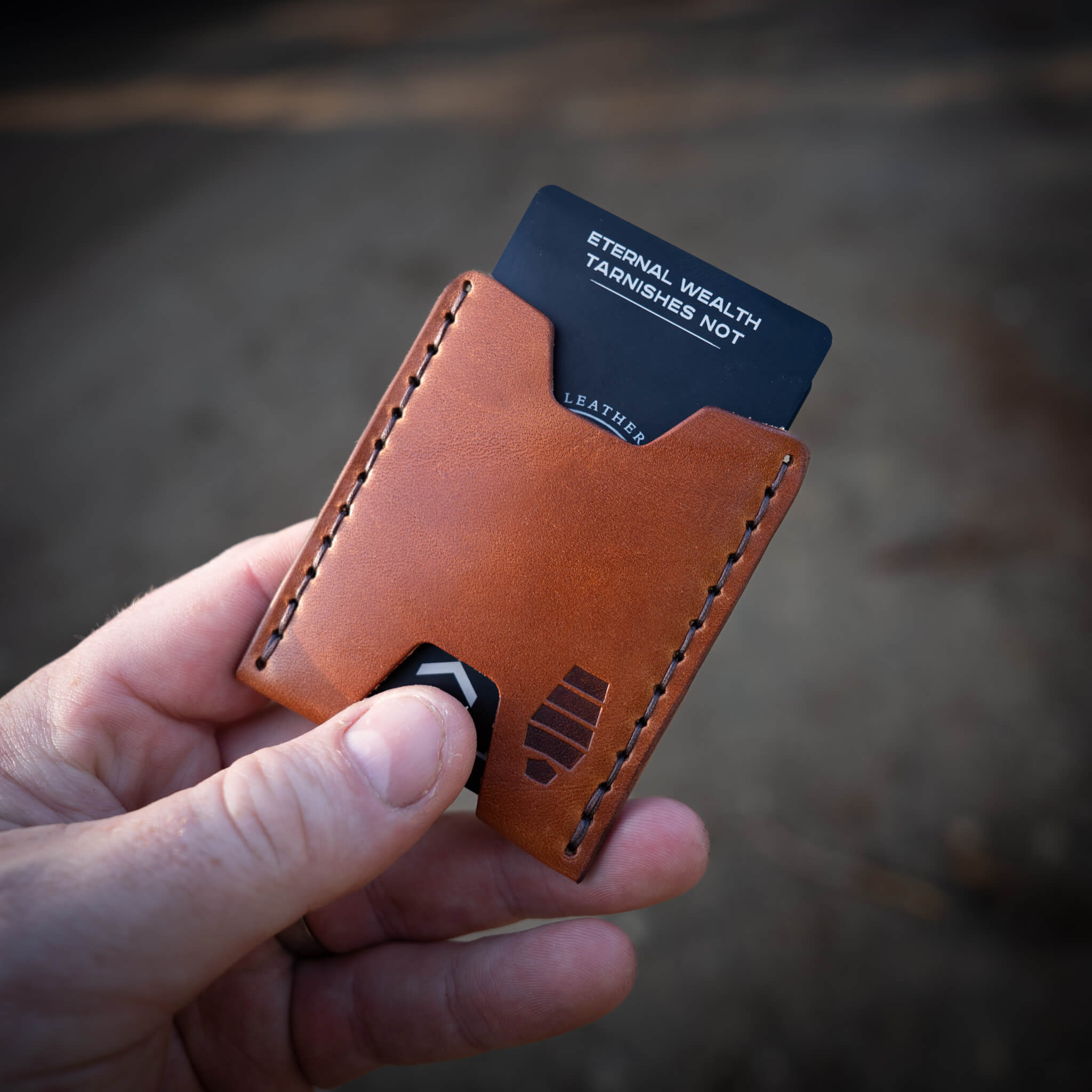 Quick-access push slot being used to slide a card from the Ulysses minimalist card wallet.