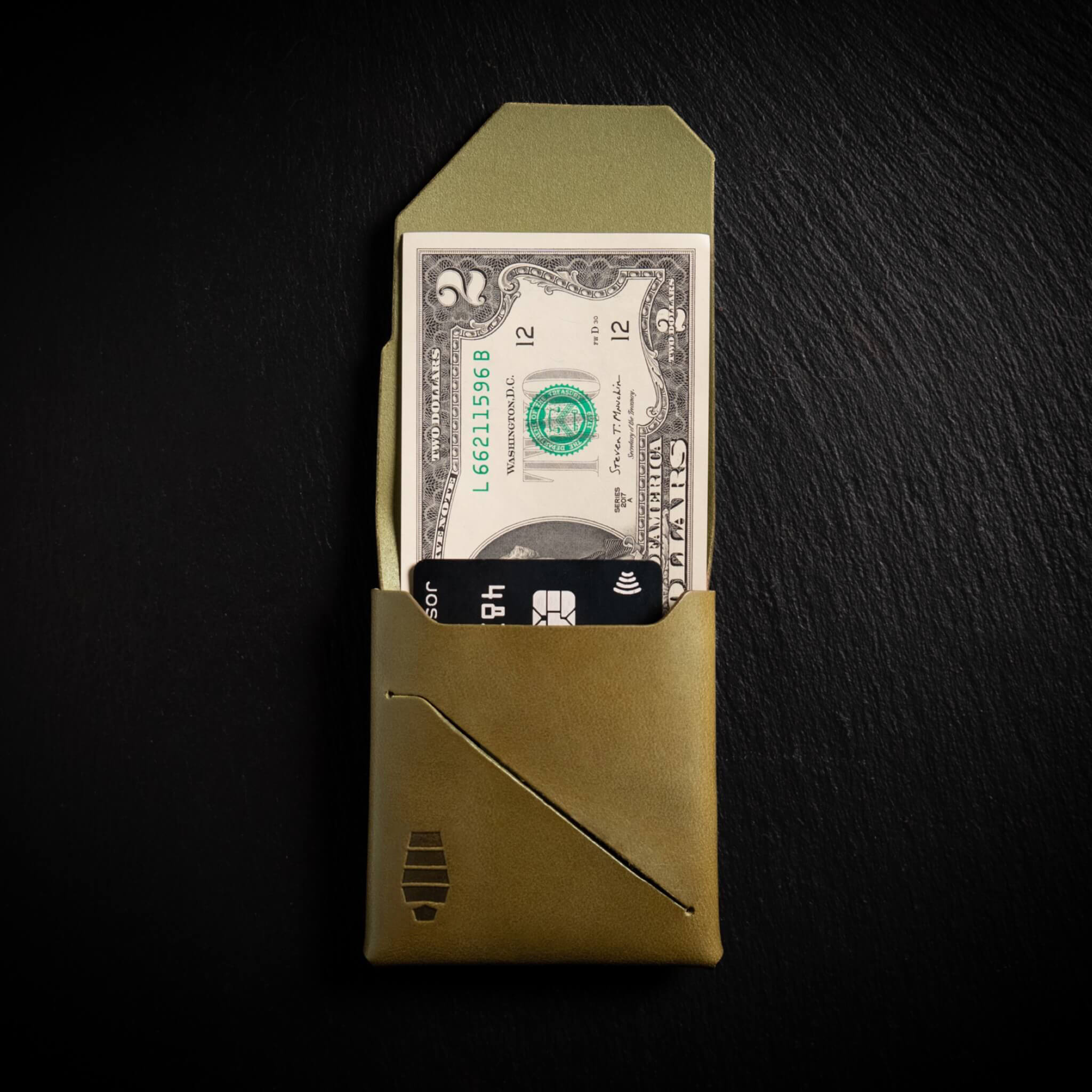 Voyager minimalist wallet in Ranger Green unfolded and open showing cash visible in Tuck & Go billfold pocket and its slim profile with stitchless leather construction
